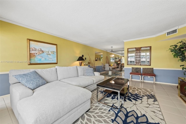 tiled living room featuring visible vents, a textured ceiling, baseboards, and ornamental molding