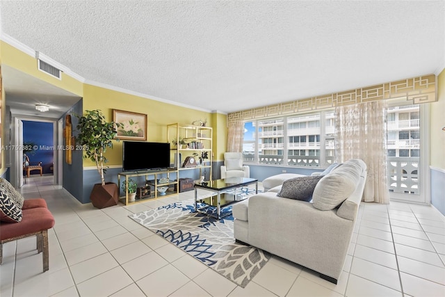 tiled living area with visible vents, a textured ceiling, and ornamental molding