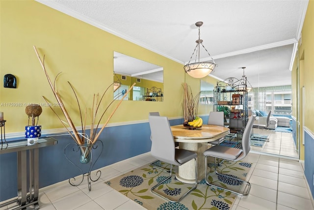 dining room with tile patterned flooring, a textured ceiling, baseboards, and ornamental molding