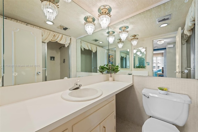 full bathroom with an inviting chandelier, toilet, visible vents, and a textured ceiling