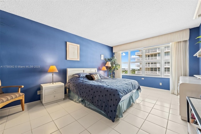 bedroom with tile patterned floors, a textured ceiling, and baseboards