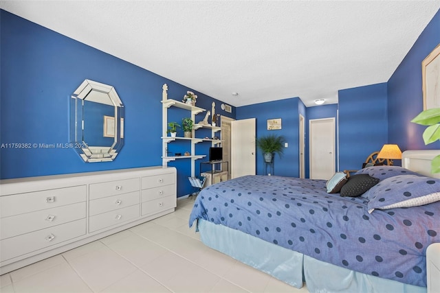 tiled bedroom featuring a textured ceiling