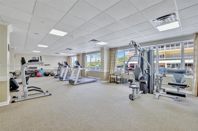 gym with a paneled ceiling, baseboards, and carpet floors