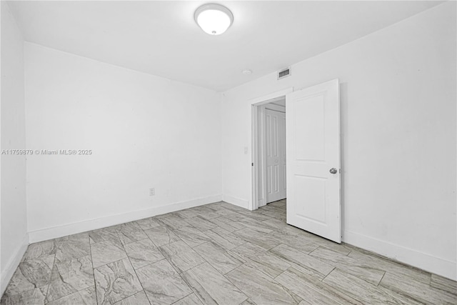 spare room featuring baseboards and visible vents