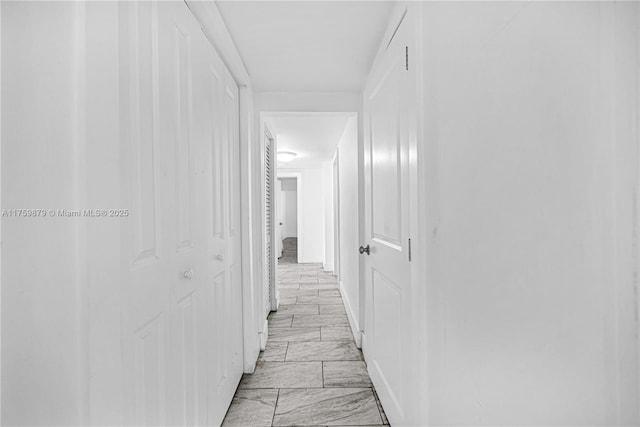 hallway featuring marble finish floor