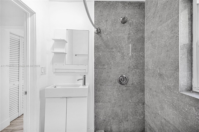 full bath featuring vanity and a tile shower