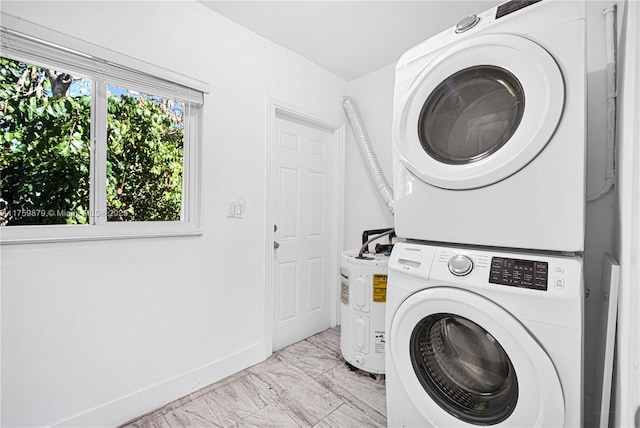 clothes washing area with laundry area, marble finish floor, baseboards, and stacked washer and dryer