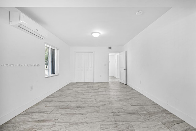empty room with a wall unit AC and baseboards