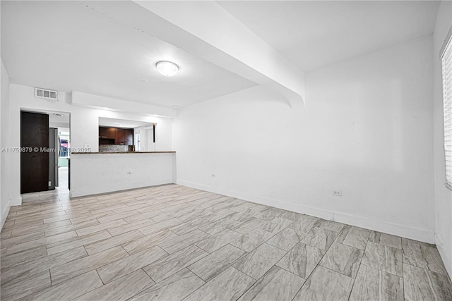 unfurnished living room with visible vents and baseboards