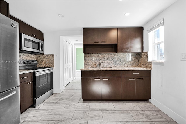 kitchen featuring marble finish floor, a sink, stainless steel appliances, decorative backsplash, and dark brown cabinets