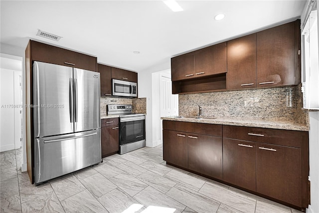 kitchen with visible vents, a sink, dark brown cabinetry, stainless steel appliances, and open shelves