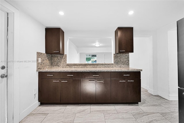 kitchen featuring backsplash and dark brown cabinets