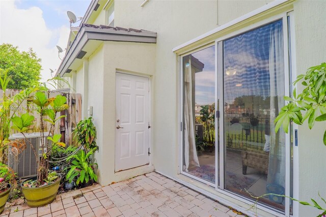 2853 SE 1st Dr Unit 4, Homestead, FL 33033 - property entrance with cooling unit, a patio area, and stucco siding