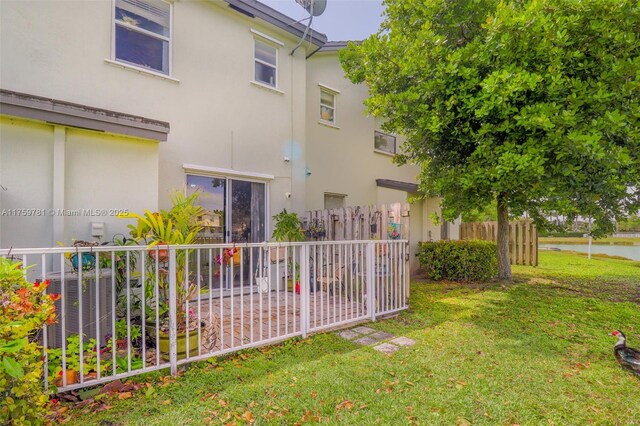 2853 SE 1st Dr Unit 4, Homestead, FL 33033 - exterior space featuring a water view, fence, stucco siding, cooling unit, and a lawn