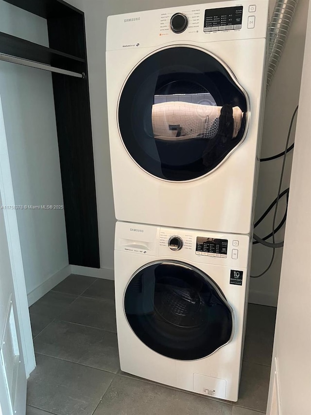 227 NE 2nd St Unit 1910, Miami, FL 33132 - laundry area featuring stacked washer / drying machine, baseboards, dark tile patterned floors, and laundry area