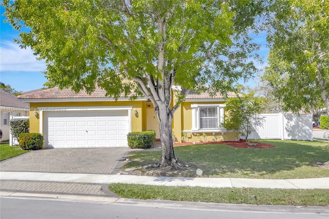 single story home with fence, stucco siding, a front lawn, a tile roof, and decorative driveway