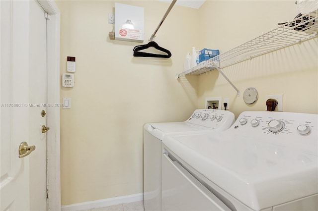 clothes washing area with baseboards, laundry area, and washer and clothes dryer