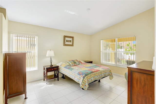 bedroom featuring vaulted ceiling, light tile patterned floors, and baseboards