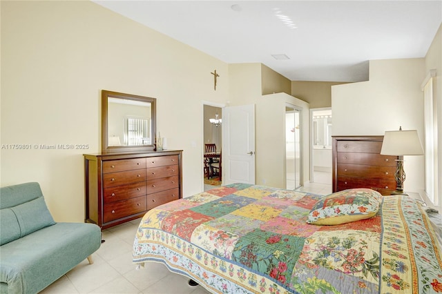 bedroom featuring light tile patterned flooring, a notable chandelier, and connected bathroom