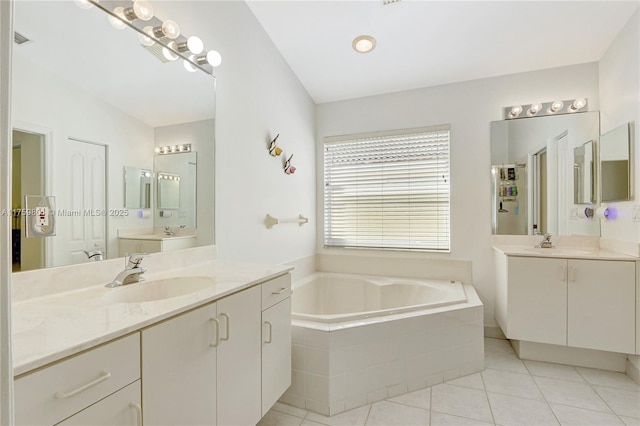 bathroom featuring visible vents, two vanities, a sink, tile patterned floors, and a bath