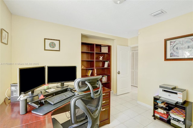 office featuring light tile patterned floors, visible vents, and baseboards