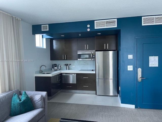 kitchen featuring visible vents, stainless steel appliances, light countertops, and a sink