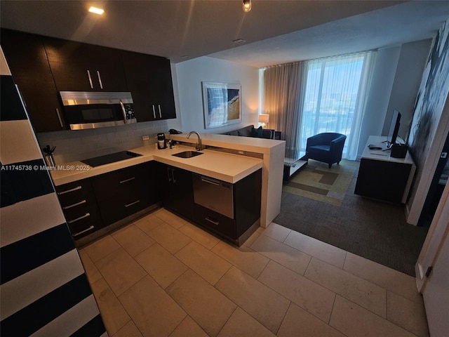 17315 Collins Ave Unit 1107, Sunny Isles Beach, FL 33160 - kitchen featuring stainless steel microwave, dark cabinets, black electric stovetop, and a peninsula