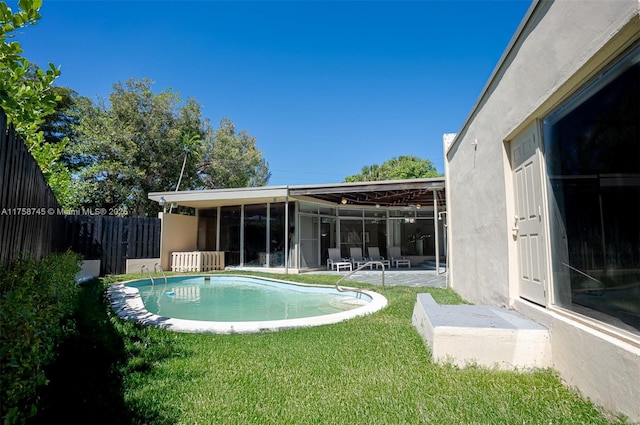 view of pool with fence, a yard, a sunroom, a fenced in pool, and a patio area