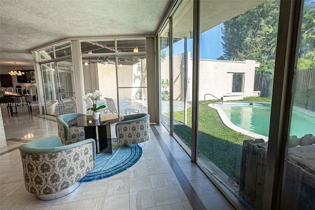 sunroom featuring an inviting chandelier