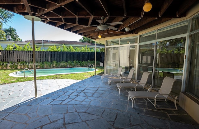 view of patio featuring a fenced in pool, a sunroom, and fence