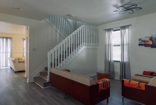 interior space with stairs, wood finished floors, and baseboards