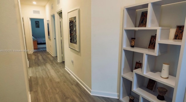 corridor with wood finished floors, visible vents, and baseboards