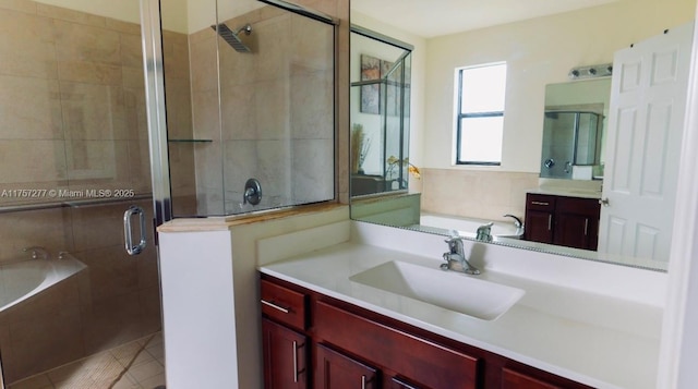 full bath with tile patterned floors, a shower stall, vanity, and a garden tub