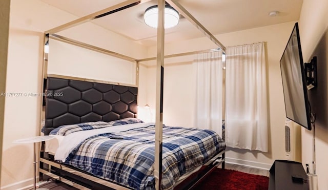 bedroom with baseboards and wood finished floors