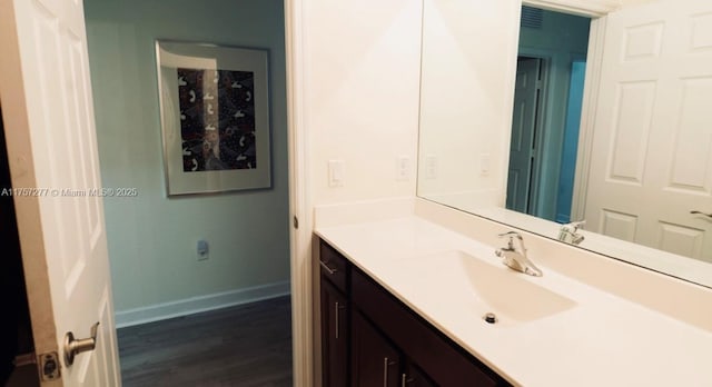 bathroom with vanity, baseboards, and wood finished floors