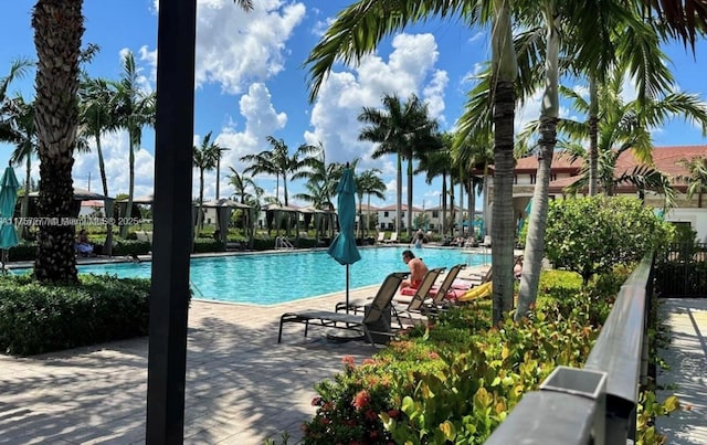 community pool with a patio and fence