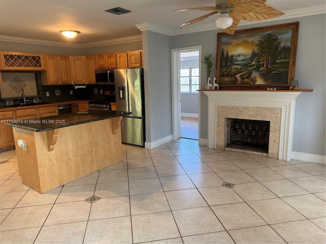 kitchen featuring visible vents, ornamental molding, a sink, stainless steel appliances, and light tile patterned floors