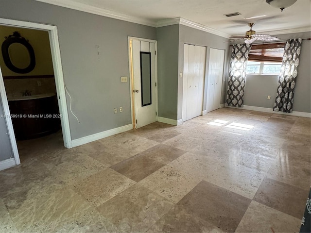 unfurnished bedroom with baseboards, visible vents, stone finish floor, multiple closets, and crown molding