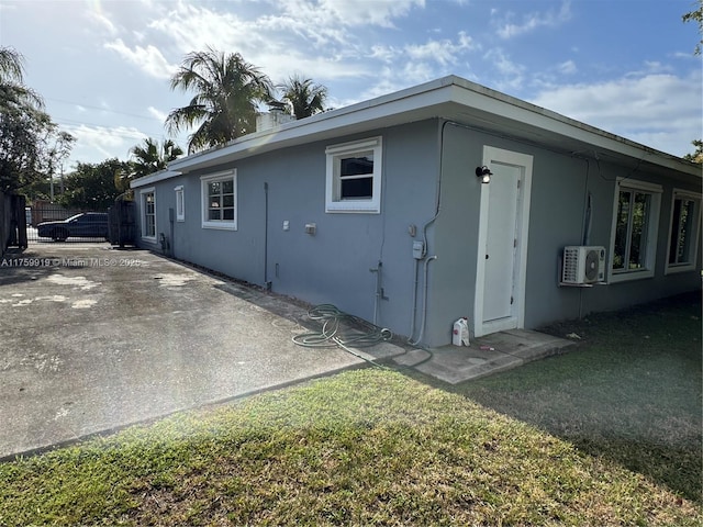 view of side of property featuring ac unit, stucco siding, a patio, and fence