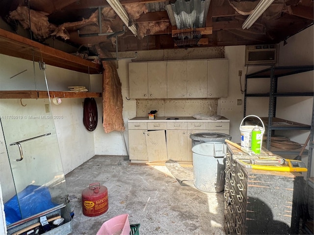 kitchen with a wall unit AC, unfinished concrete flooring, and light countertops