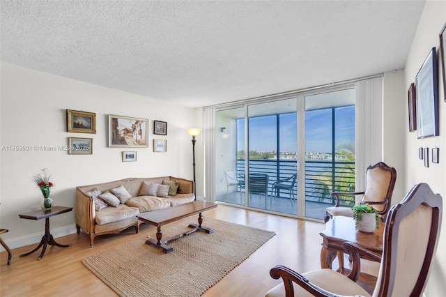 1175 NE Miami Gardens Dr Unit 610, Miami, FL 33179 - living area with a wall of windows, wood finished floors, a textured ceiling, and a water view