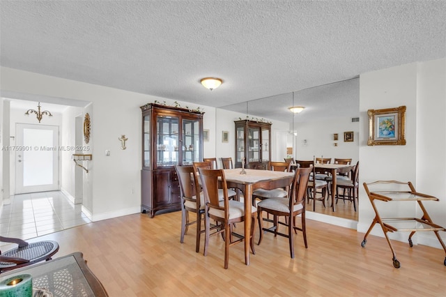 1175 NE Miami Gardens Dr Unit 610, Miami, FL 33179 - dining space with a textured ceiling, light wood-style flooring, baseboards, and a chandelier