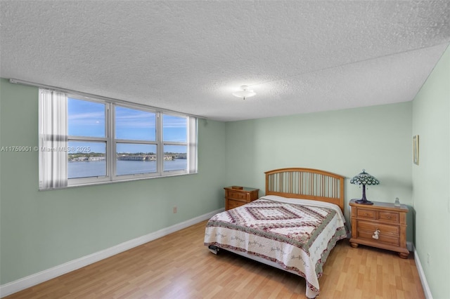 1175 NE Miami Gardens Dr Unit 610, Miami, FL 33179 - bedroom featuring wood finished floors, a water view, baseboards, and a textured ceiling