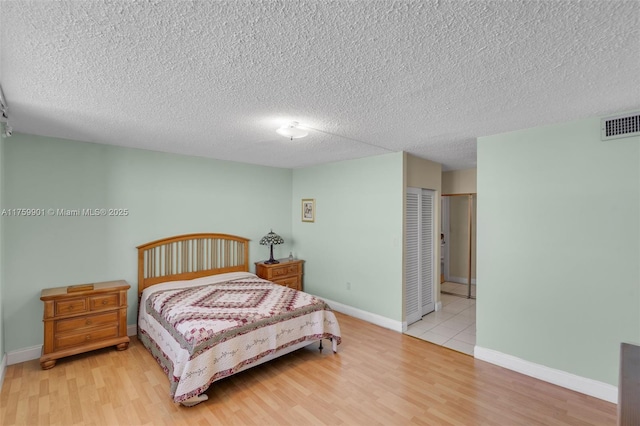 1175 NE Miami Gardens Dr Unit 610, Miami, FL 33179 - bedroom featuring wood finished floors, a textured ceiling, baseboards, and a closet