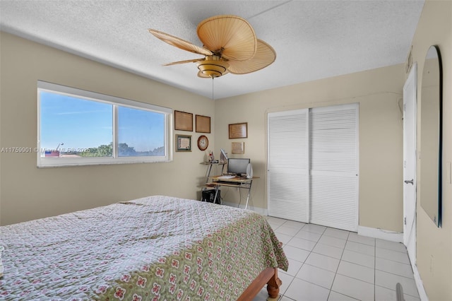 1175 NE Miami Gardens Dr Unit 610, Miami, FL 33179 - bedroom featuring a closet, baseboards, light tile patterned floors, a ceiling fan, and a textured ceiling