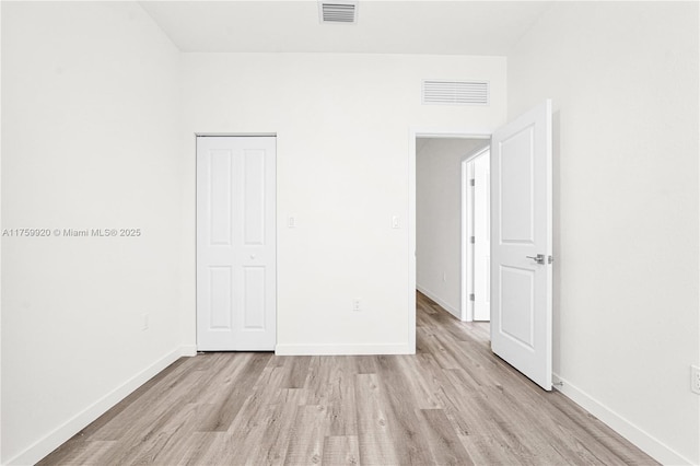 unfurnished bedroom featuring baseboards, visible vents, and light wood-type flooring