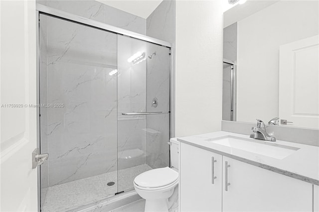 full bath featuring a marble finish shower, toilet, and vanity