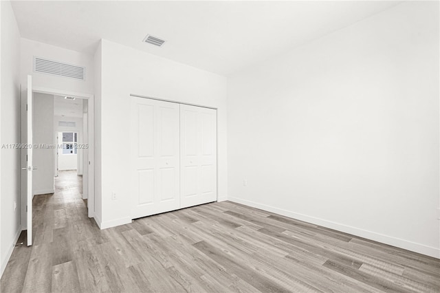 unfurnished bedroom featuring visible vents, light wood-style flooring, and baseboards