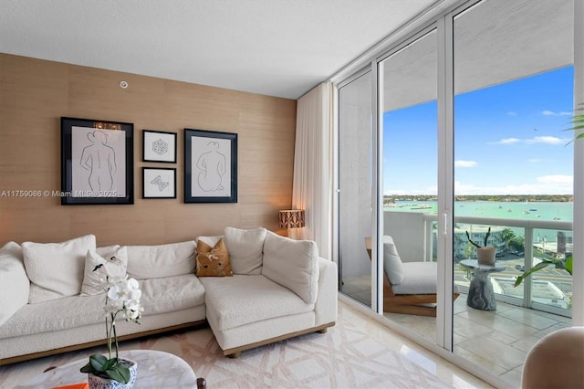 living room featuring a wall of windows and a water view