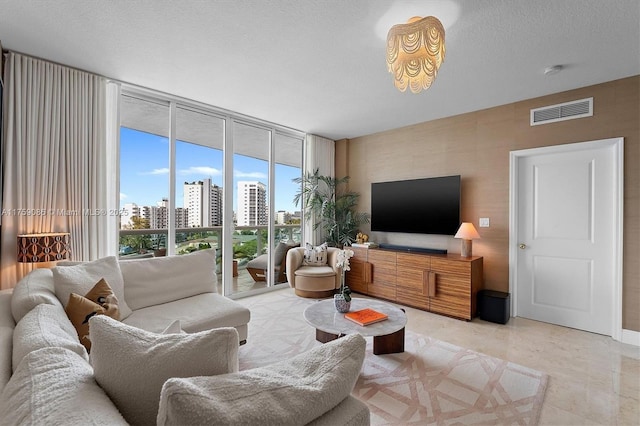 living room with visible vents, a textured ceiling, and floor to ceiling windows